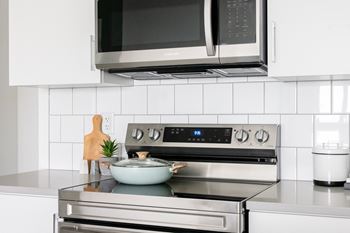 a white kitchen with a stove and a microwave